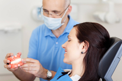 Стоматолог показывает слепок челюстей пациенту